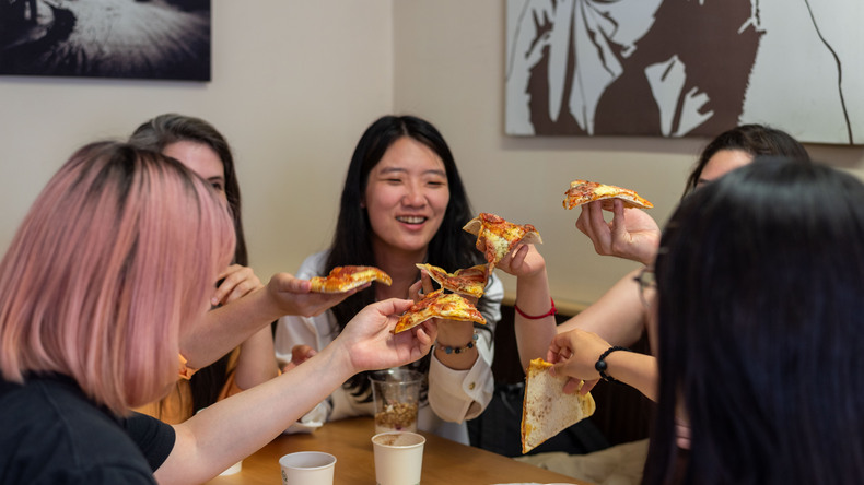 Studerende nyder pizza i caféen