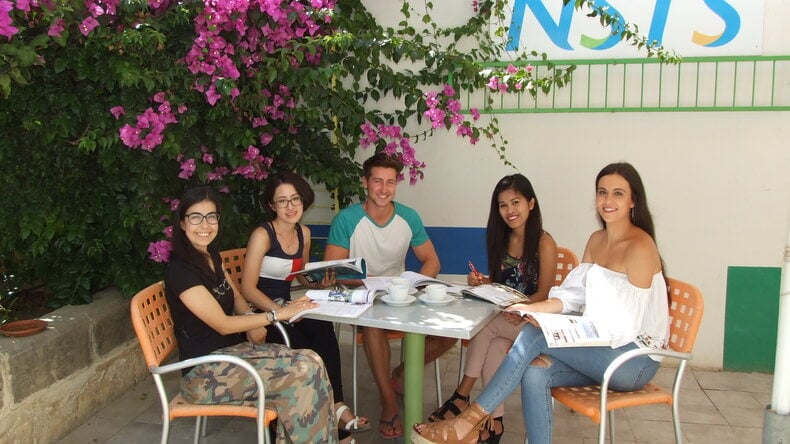 الطلاب جالسون في الخارج معًا