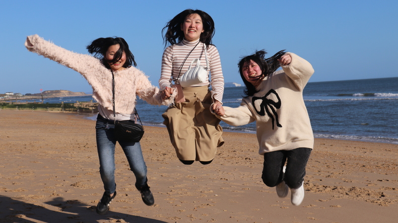 Studenter hopper på stranden, Southbourne strandtur